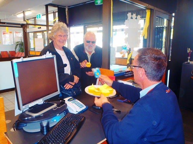 NSW Train Link - Customers Mr and Mrs Underwood enjoy a cake with Senior Customer Attendant Jon Sullivan