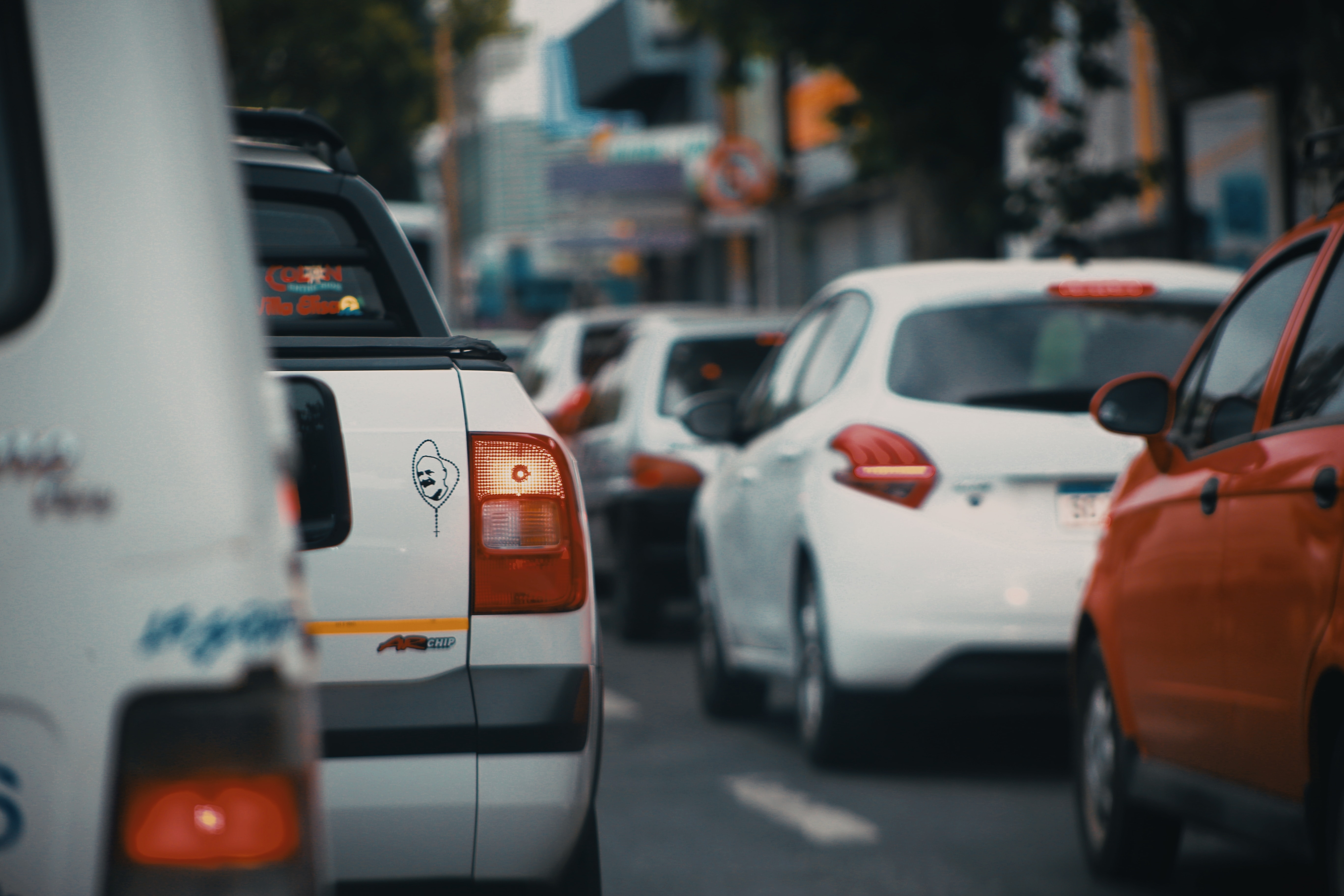 The rear view of multiple cars driving through a city street