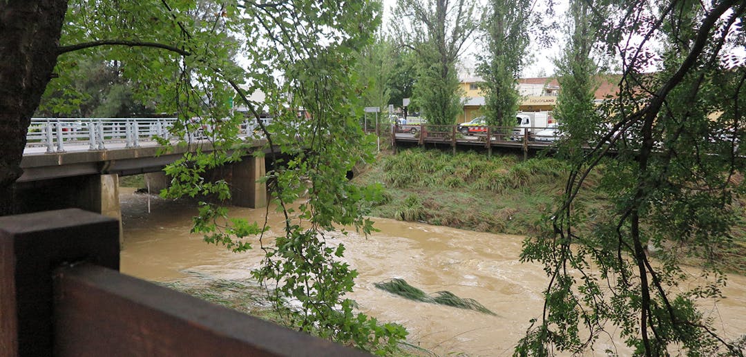 Stonequarry Creek in flood with bridge, car park, trees