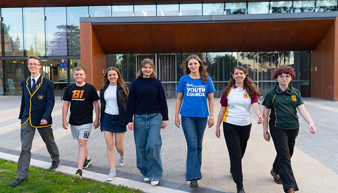 Male and female teenagers standing in a line, walking towards the camera