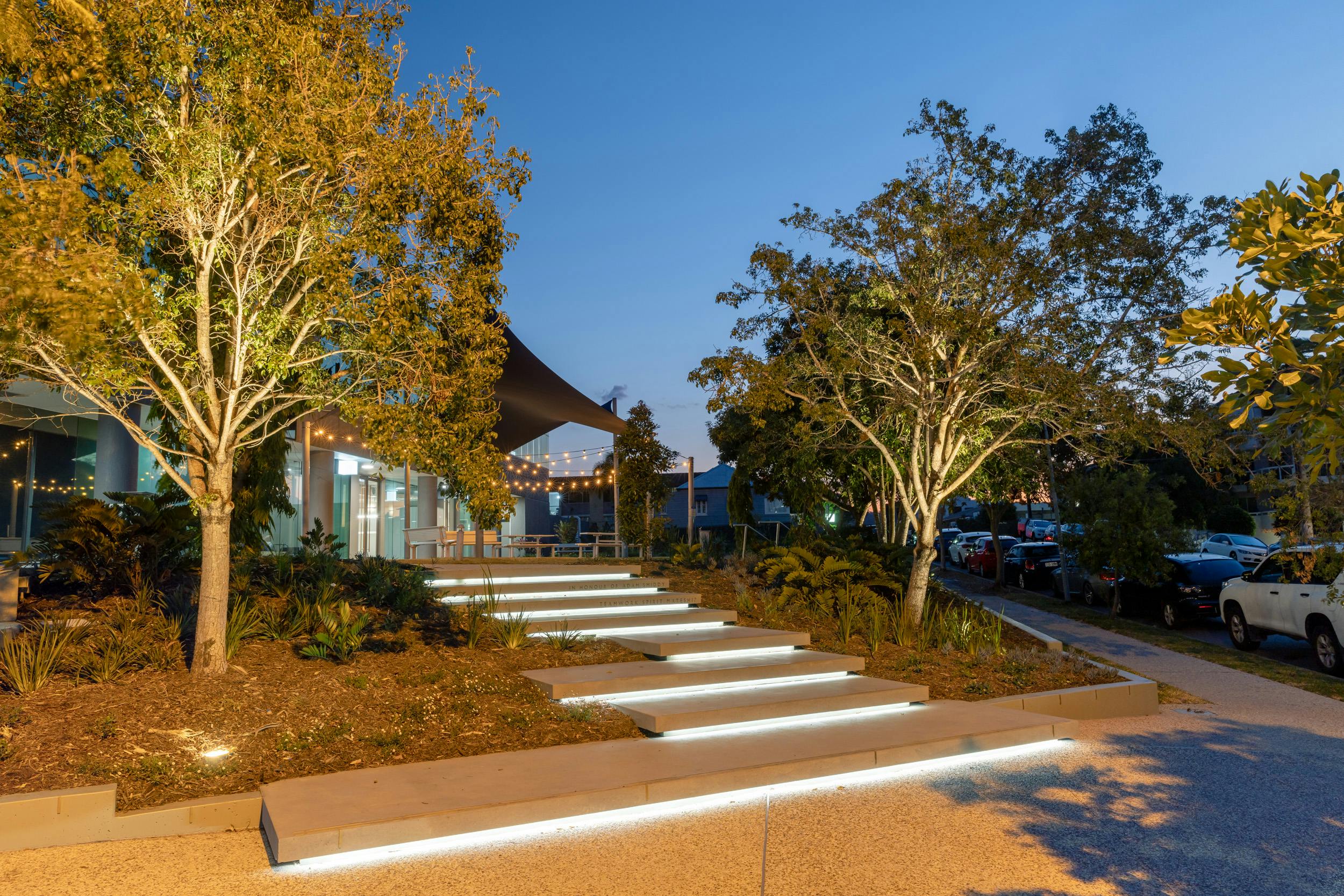 Night photo showcasing the integrated LED lighting of the concrete platforms and the creative lighting within Adam Smiddy Park