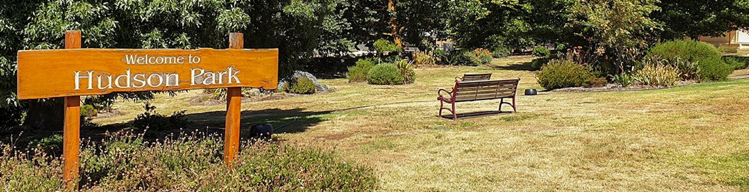 Hudson Park sign and a park bench