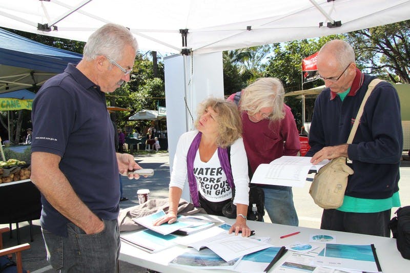 General Manager Mike Rayner (left) listens to the comments of Byrrill Creek residents Joanna Gardener and Pete Symons and Uki Village and Residents Association representative Philip Carr, at the Uki Markets community information stall.
