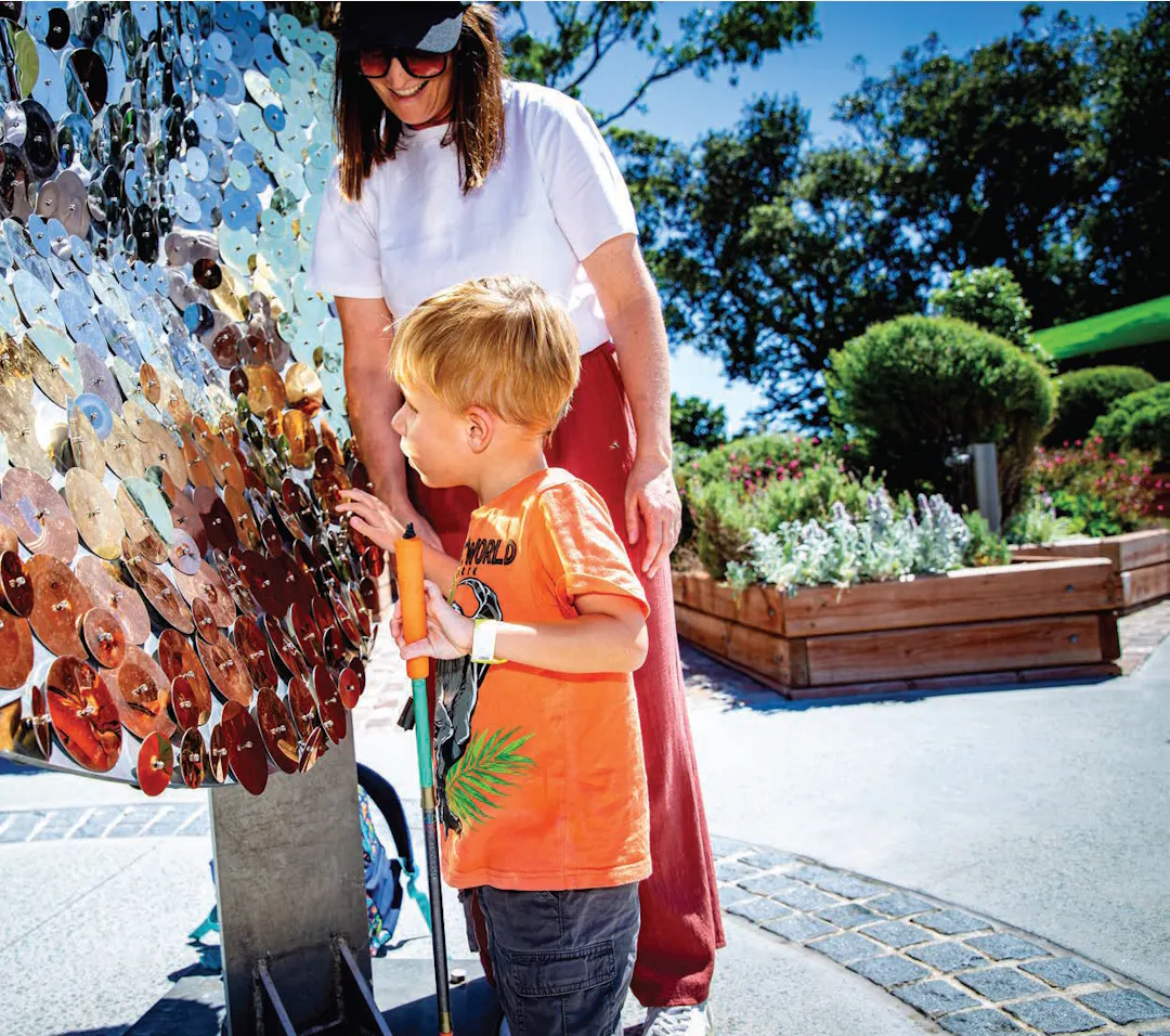 An image of a person with disability in a wheelchair smiling at a Council staff member.
