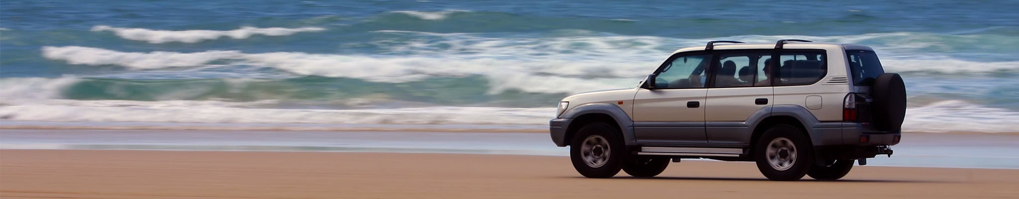 4x4 vehicle driving on a beach