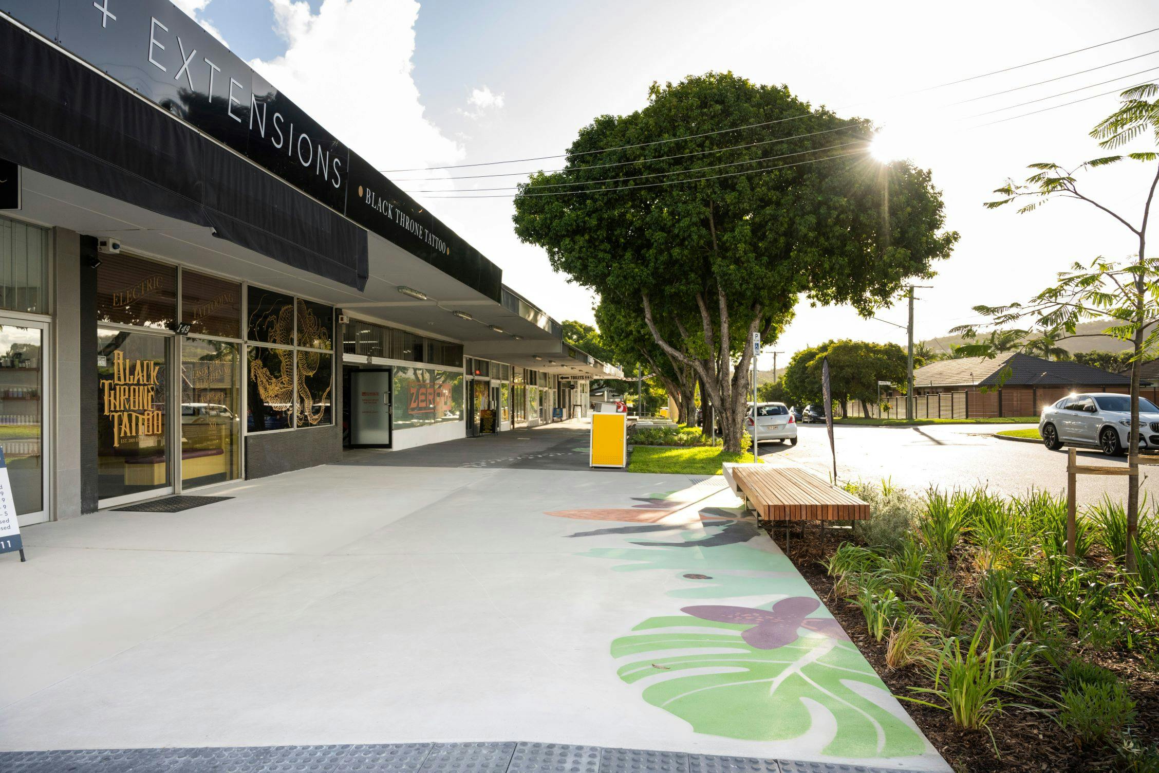 Eastern entrance looking west along Lumley Street highlighting new pavement with colourful 'Echidna Magic' design print, timber and concrete platform seating areas and new extended turf and planting beds. 