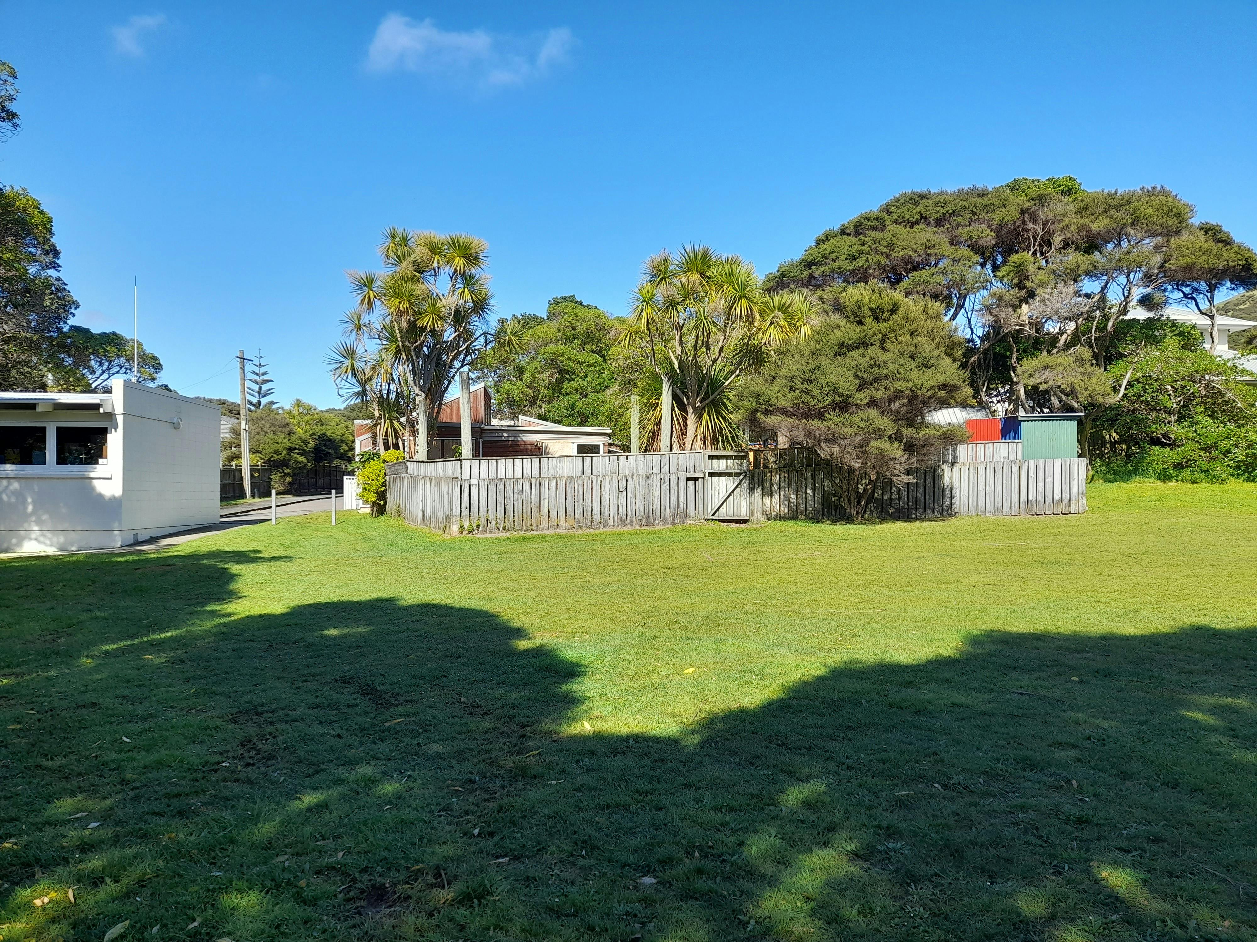 Wairaka Park reserve looking south to rear of building and fenced play area.