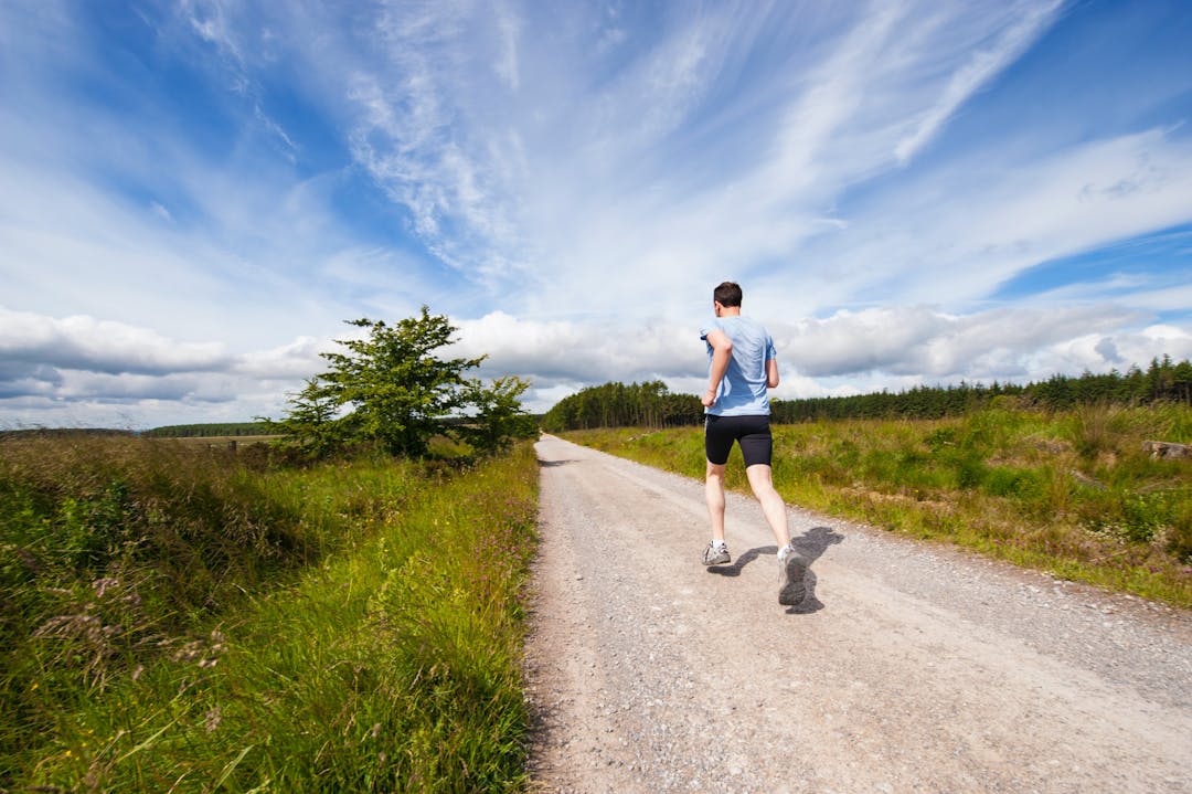 person running on gravel track