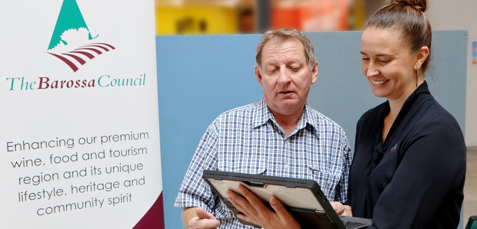 Two people chatting and looking at computer