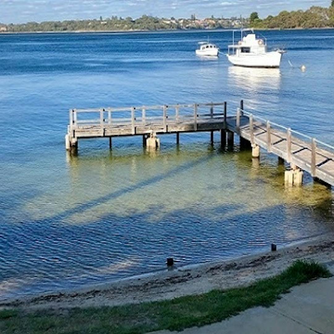 A photo of Green Place Jetty with a boat moored in the background