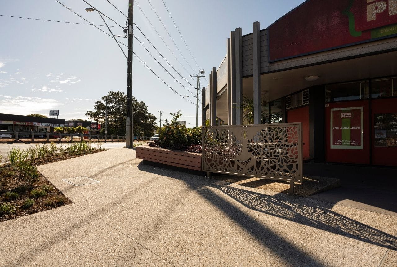 Footpath upgrade with exposed aggregate concrete finish, garden beds and balustrade with creative panel