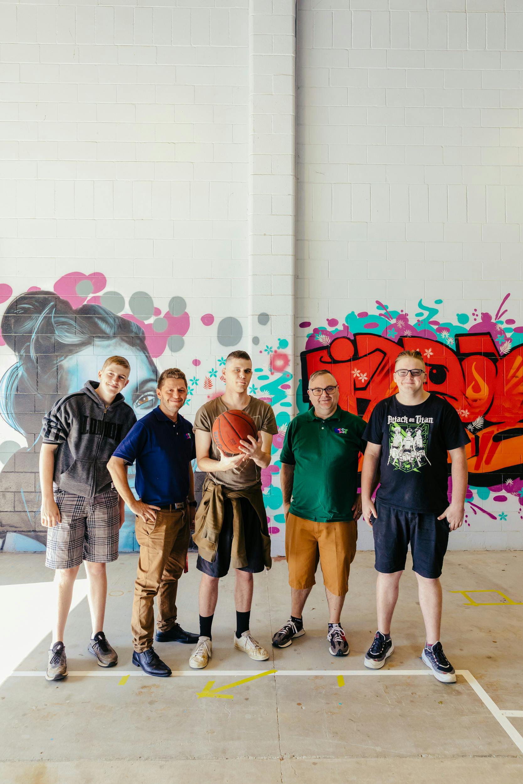Members from BEST Disability Support in Slacks Creek in front of a graffiti art mural