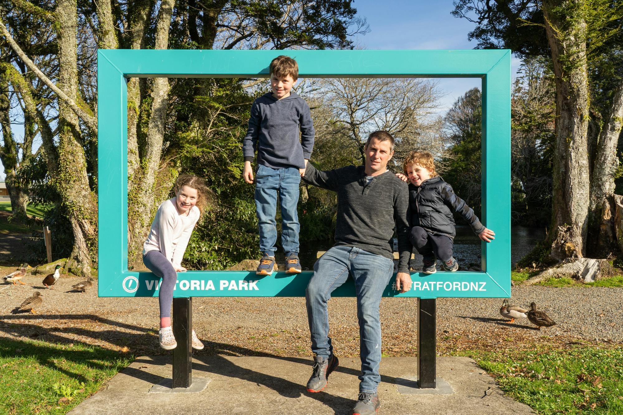 Family pose for a photo with the Victoria Park photoframe