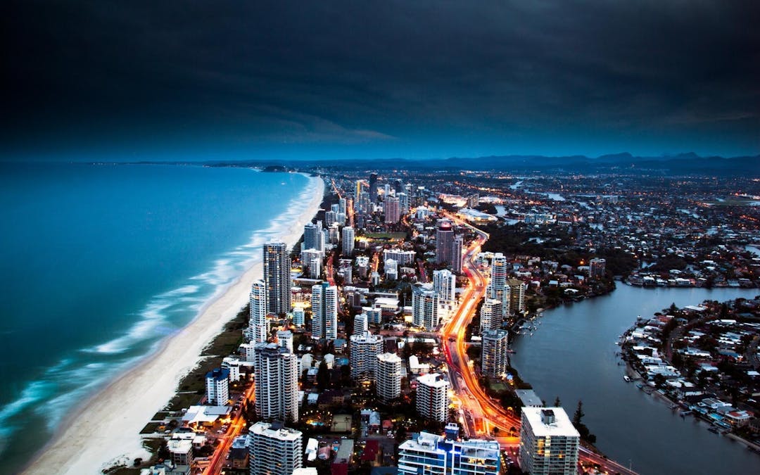 Night view over Gold Coast looking south with beach, high rise buildings, canals and arterial road