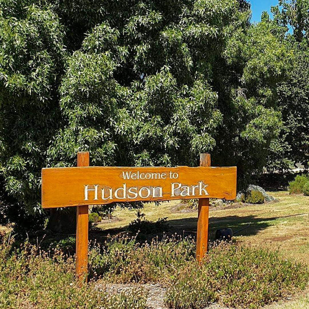 Welcome to Hudson Park sign with trees in the background