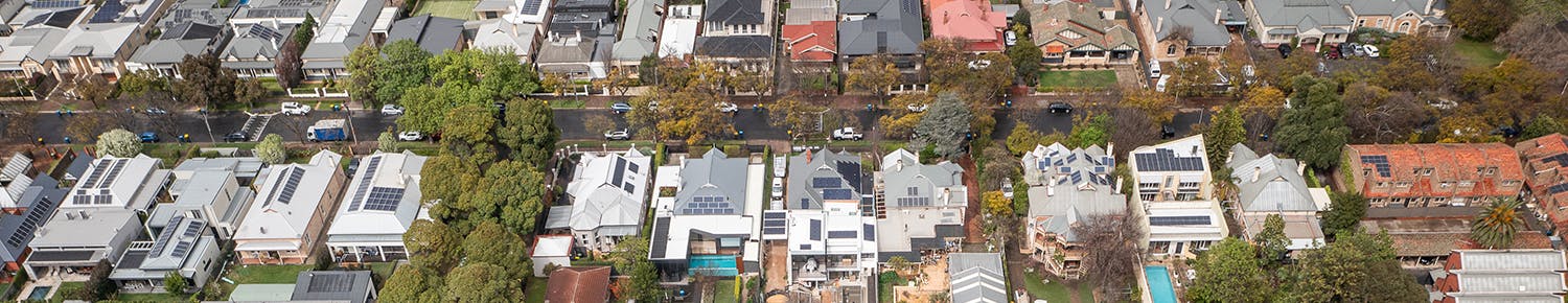 Aerial street view of homes, trees and cars on the road