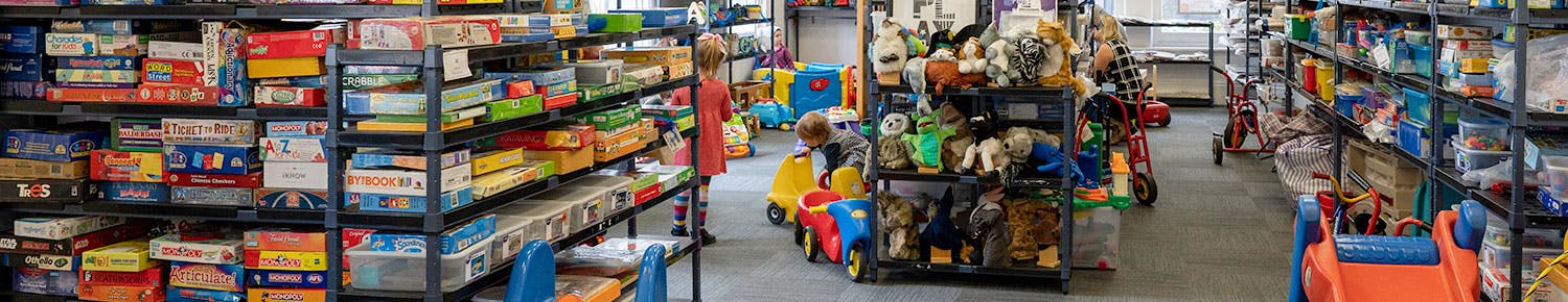 children playing in between shelves of toys at the Unley Toy Library
