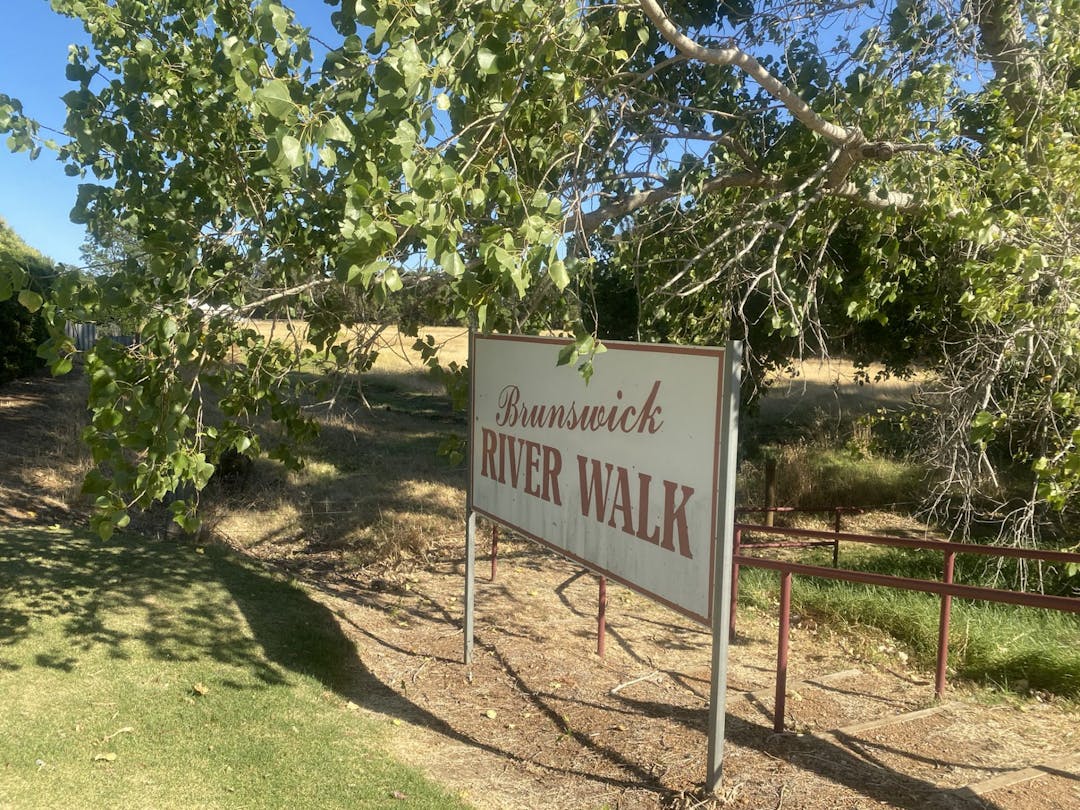 Picture of a written sign at the start of a gravel and grass track