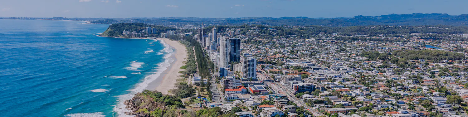 Aerial view of the coastline between Broadbeach and Burleigh Heads with beachfront high‑rise buildings and surrounding suburb