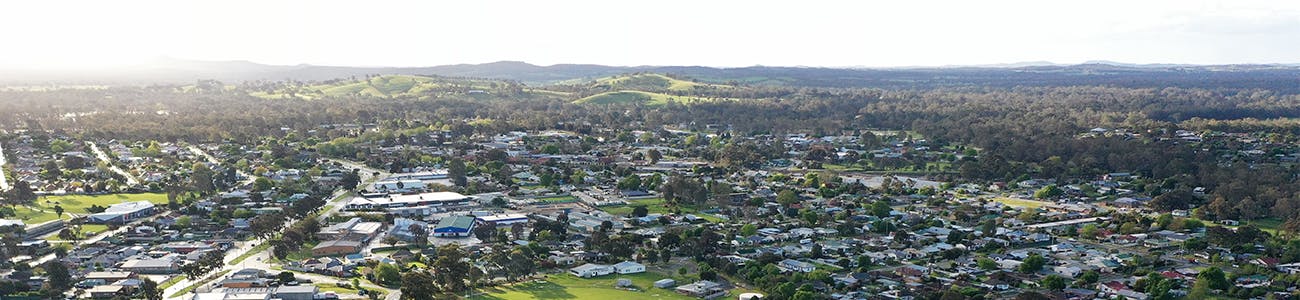 Aerial view of Seymour with green oval in foreground, houses and businesses and mountains and hills in the background