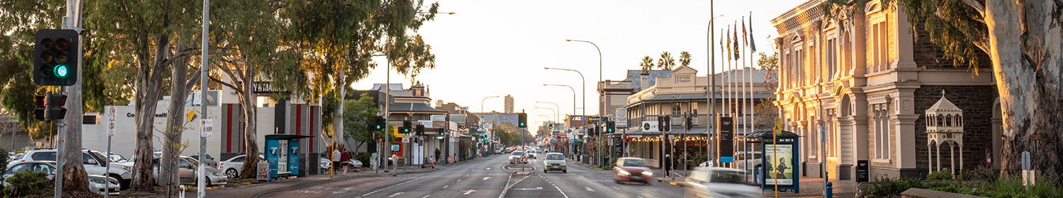 View down Unley Road showing cars and buildings including the Unley Town Hall