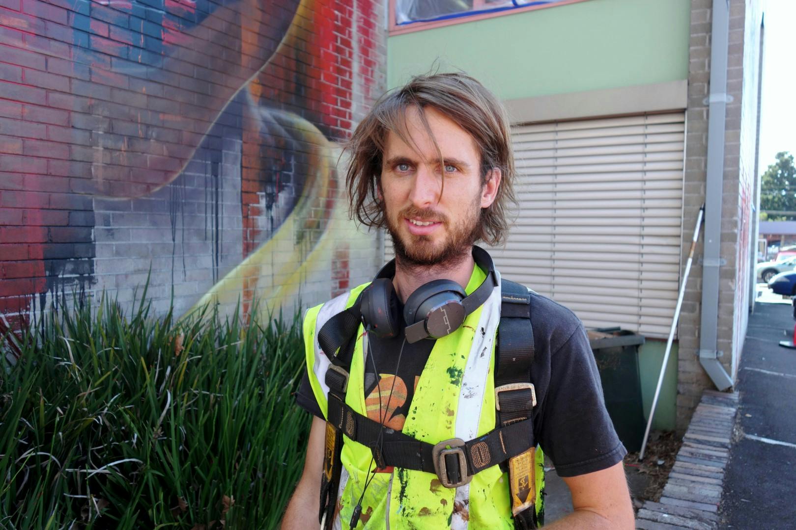 Artist Adnate painting the wall of the Shoalhaven Regional Art Gallery
