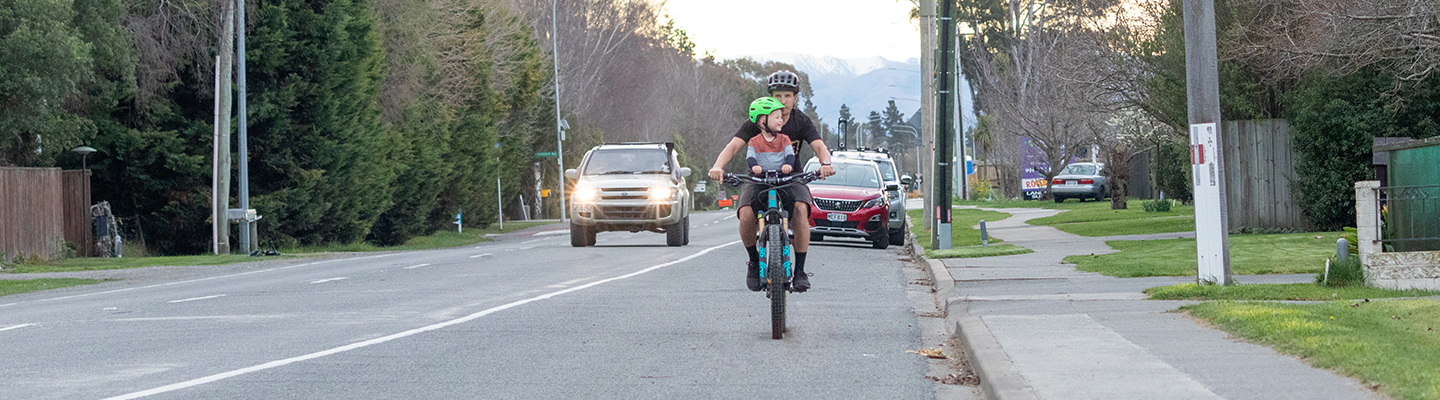 Cycling along the road shoulder on Rangiora Woodend Road