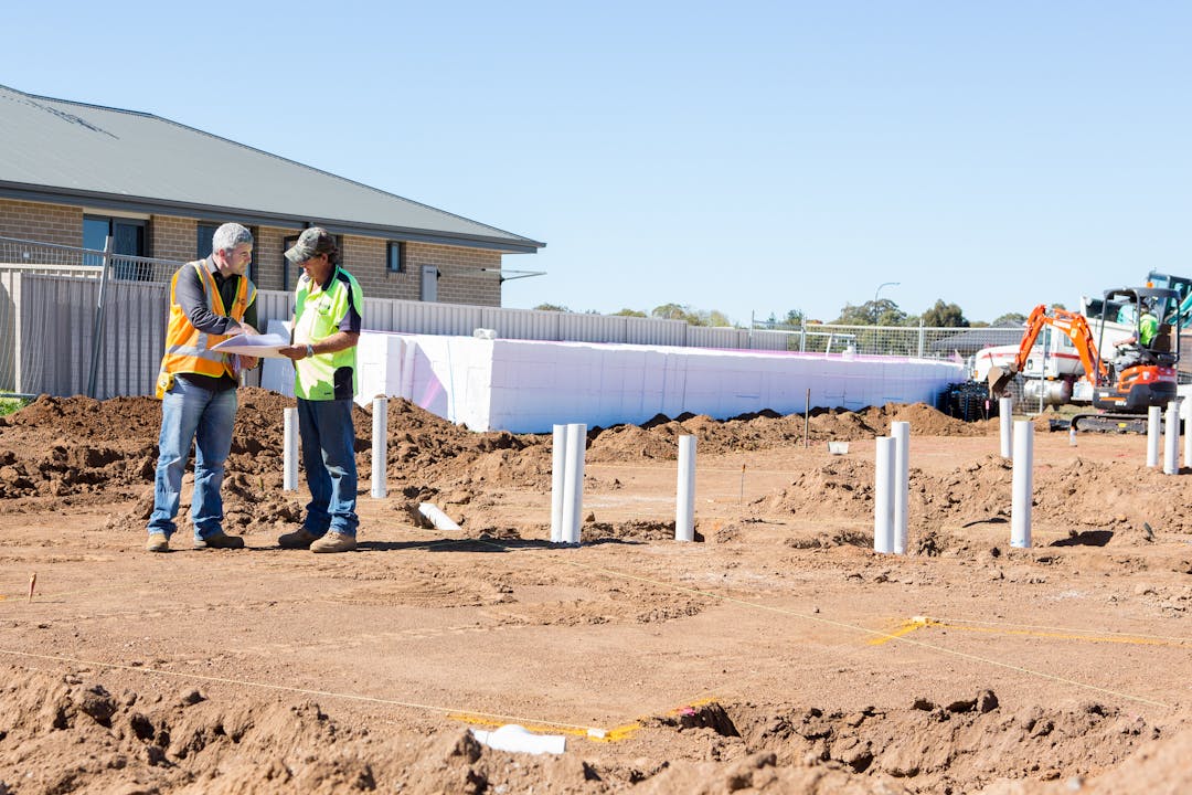 Council staff working with local builders on a house construction site.