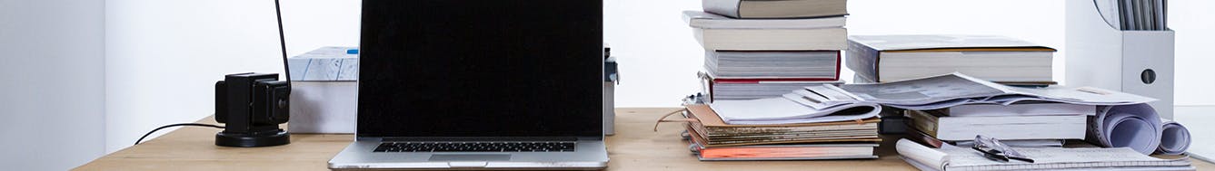 Desk with computer and paperwork - image sourced from Unsplash