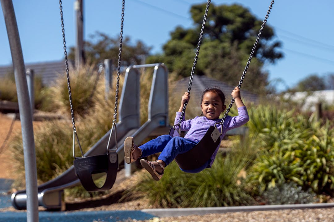 Young girl on a swing in a playground