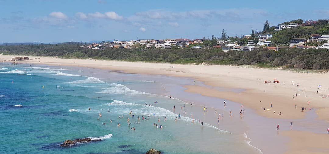 Panoramic view of Light House Beach in Port Macquarie, New South Wales, Australia showing sand and clear blue water with beach goers