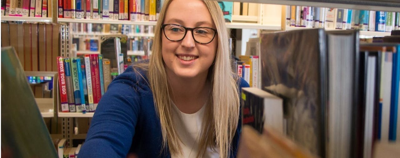 Female librarian at bookshelf