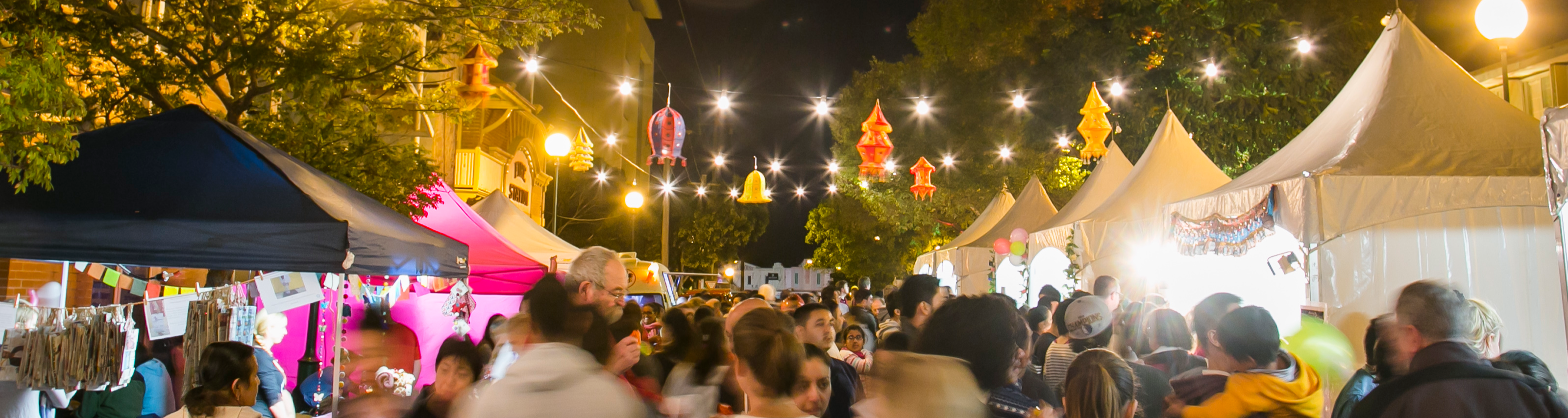 Night markets with lights strung in tree