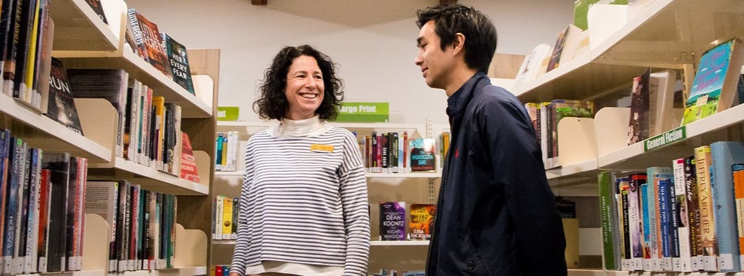 Female librarian assisting young male customer