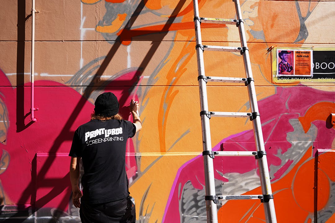 Artist painting mural on wall