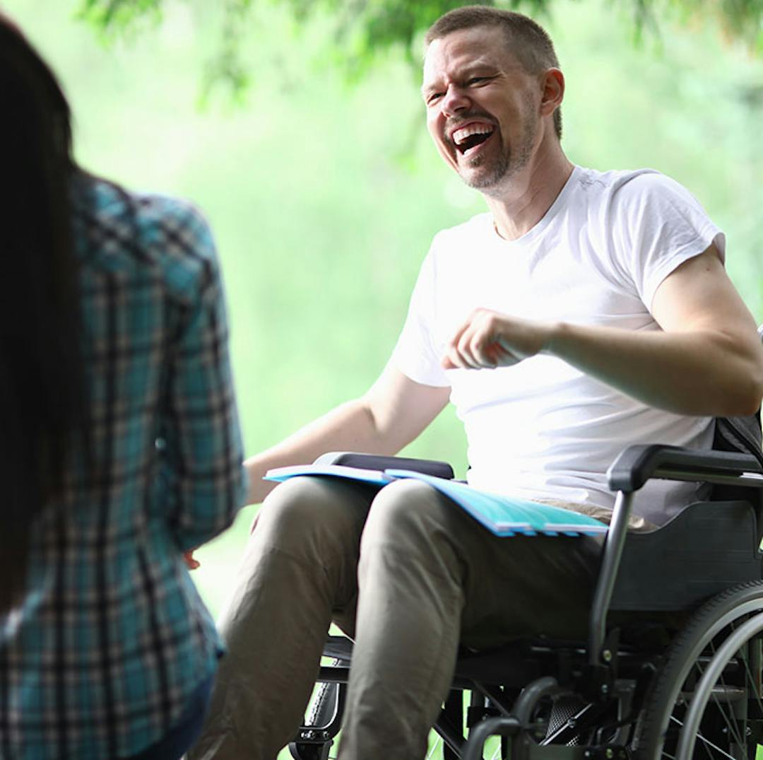 Man in wheelchair talking to woman