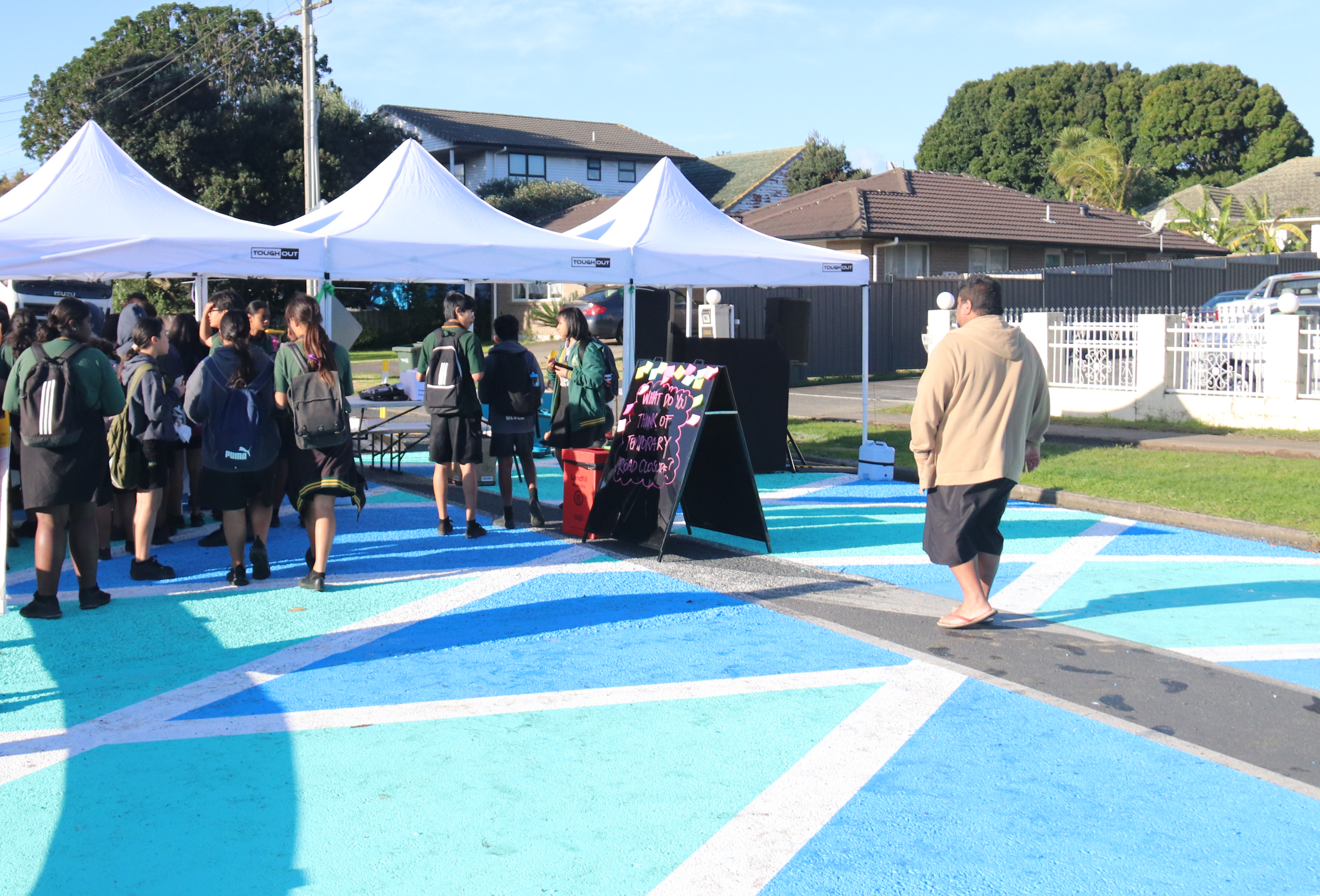 A father holding a small boy's hand as they walk through the revitalised Papatoetoe Mall.  