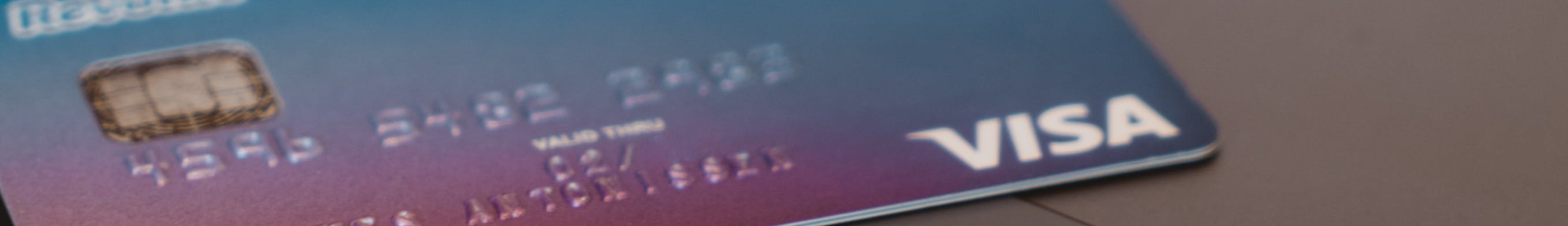Person holding credit card in front of laptop
