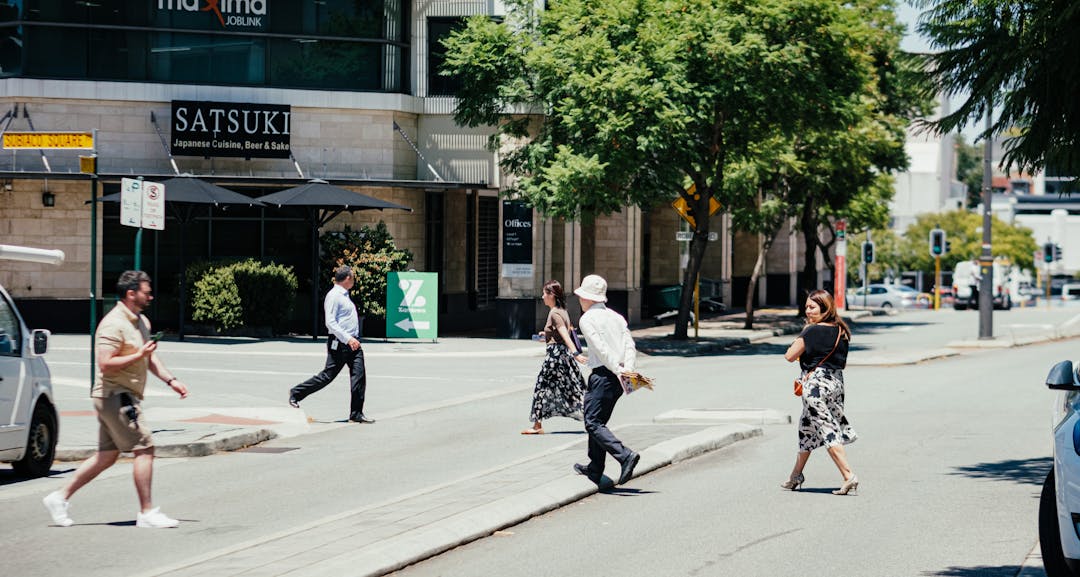 People crossing Station Street between the Coles and Woolworths complexes.