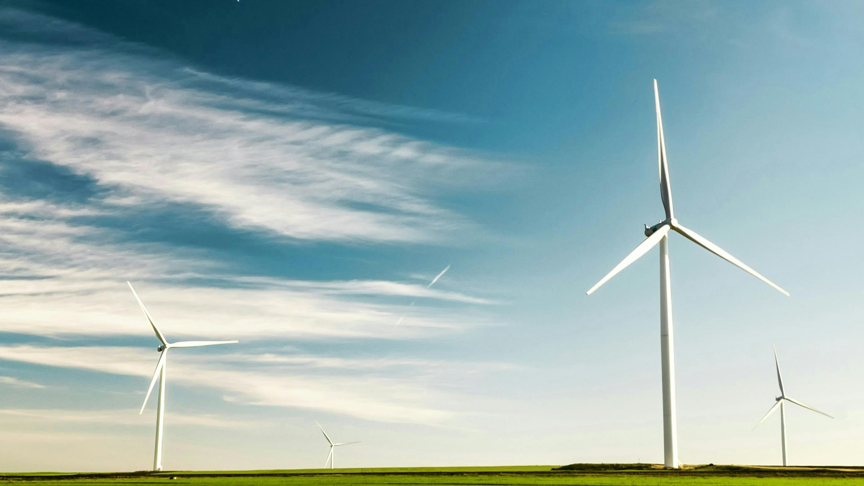 Picture of Wind Turbines on beautiful green grass with subtle clouds in the sky 