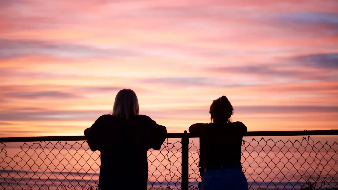 Group of people silhouetted against a bright hazy sky.