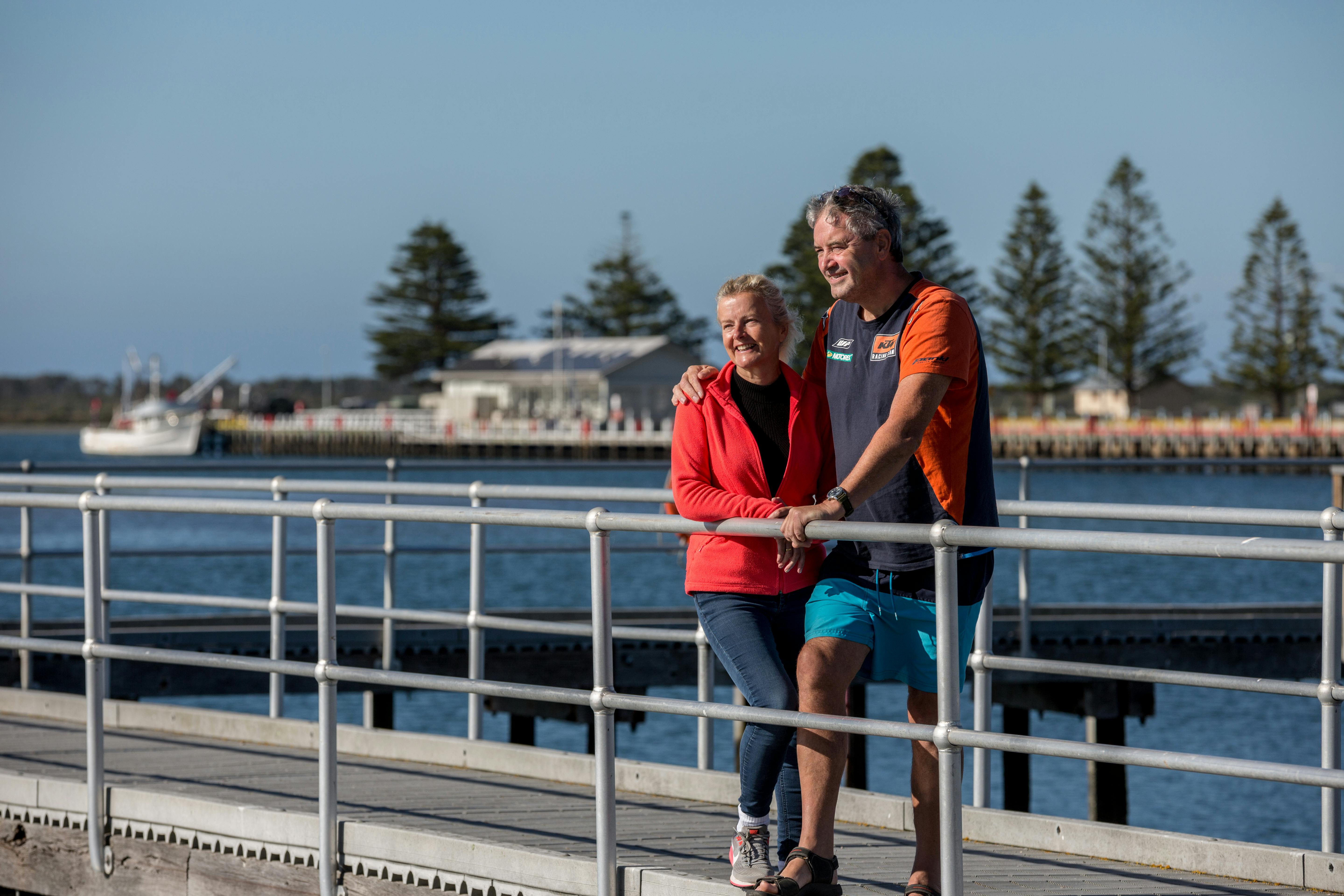 Man and Woman standing on pier at Port Albert overlooking the water.