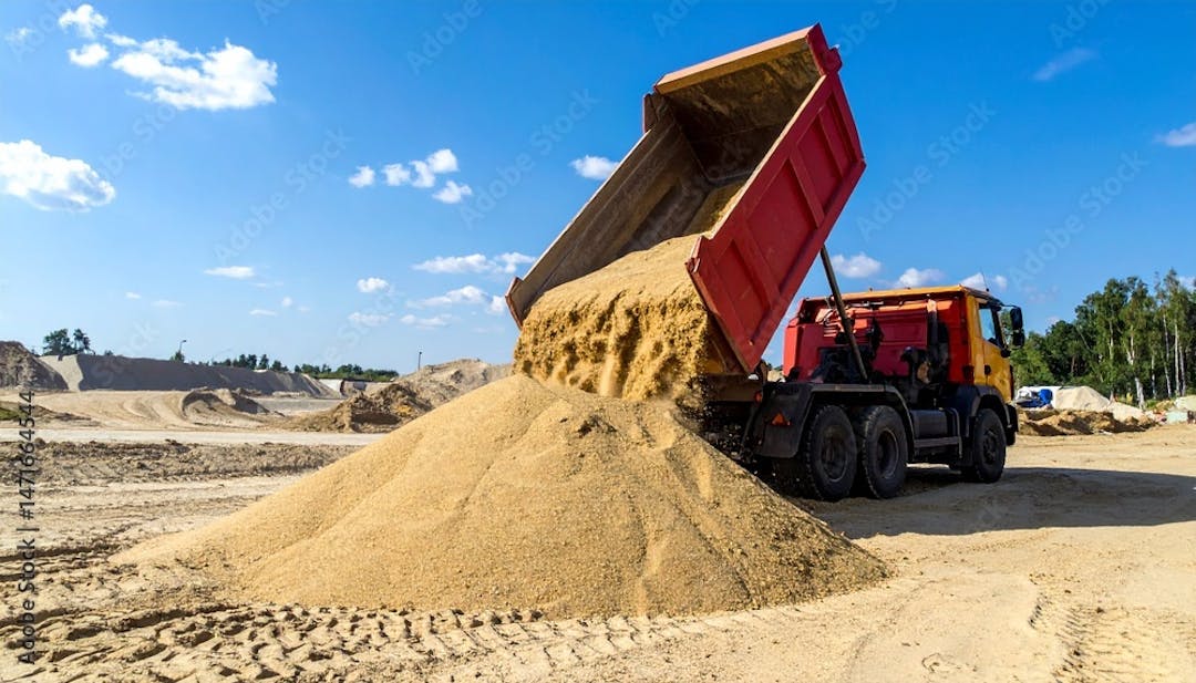 Truck emptying sand in pit