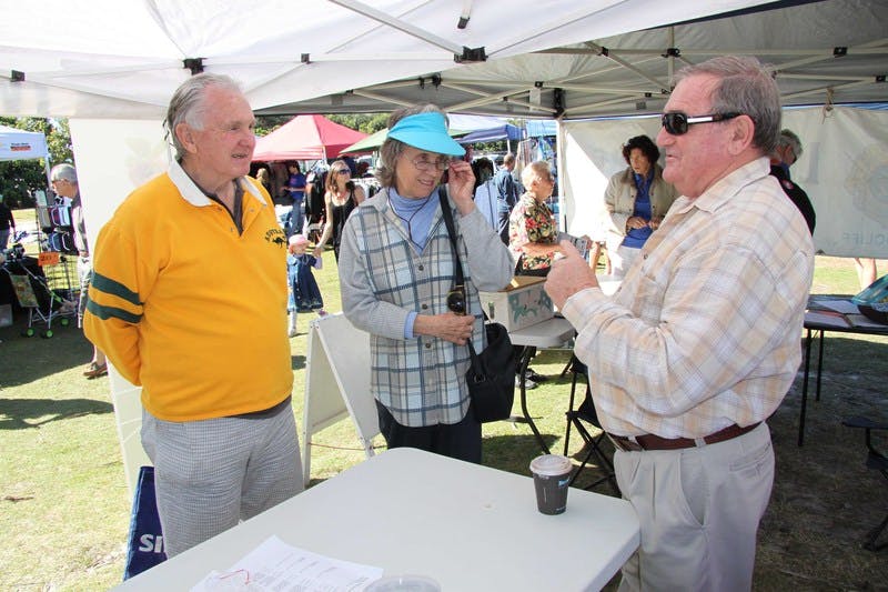 Long-serving Tweed Councillor Warren Polglase (right) talks to Kingscliff residents Ray and Jean Cole during the community information session at the town's markets. 