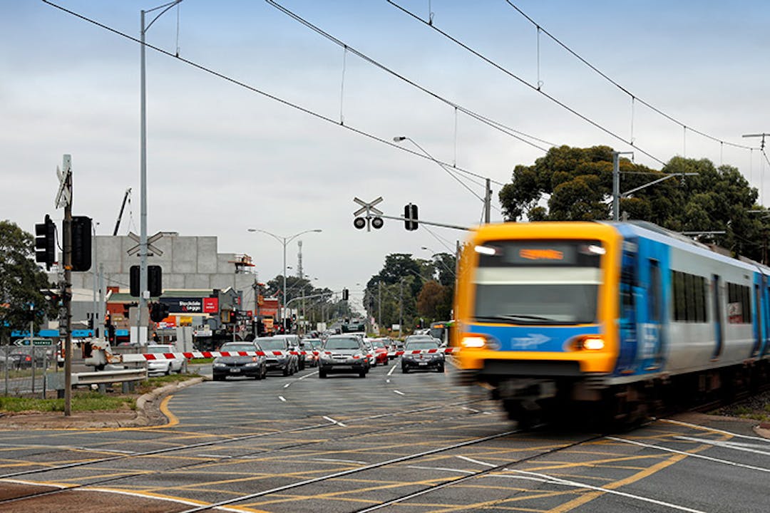 Train traveling through level crossing at High Street in Reservoir