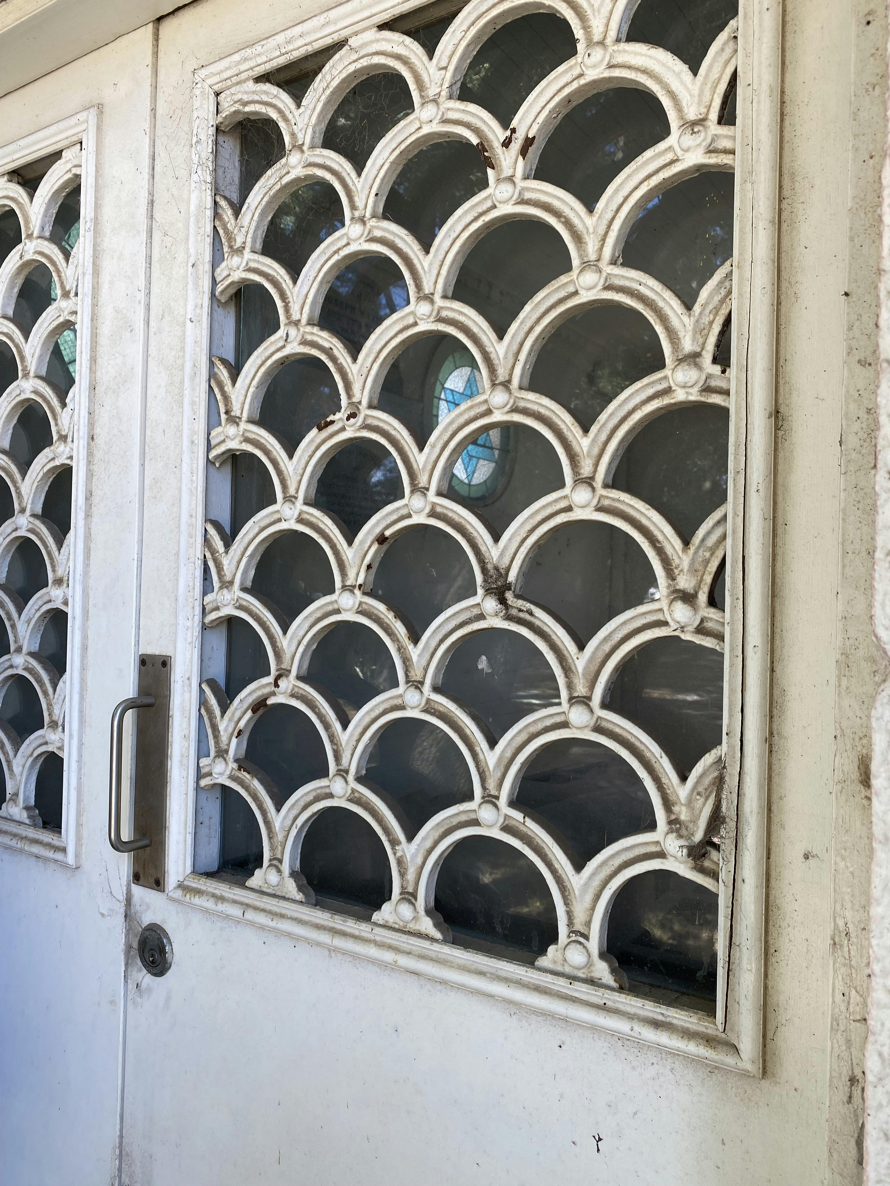 Image of chapel doors with a cast iron pattern in interlocking semi-circles