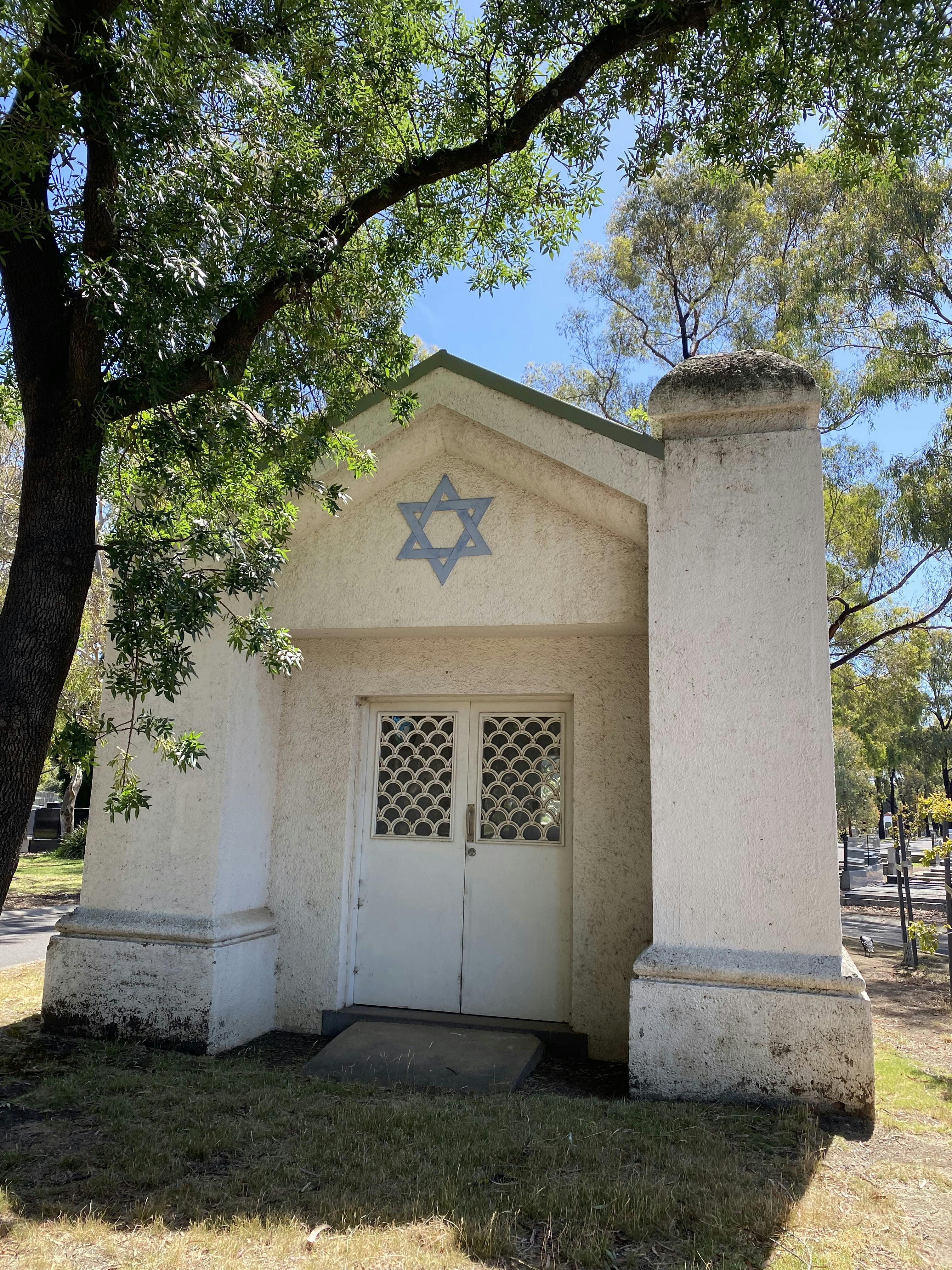 Image of Jewish mortuary chapel and a tree on the left.