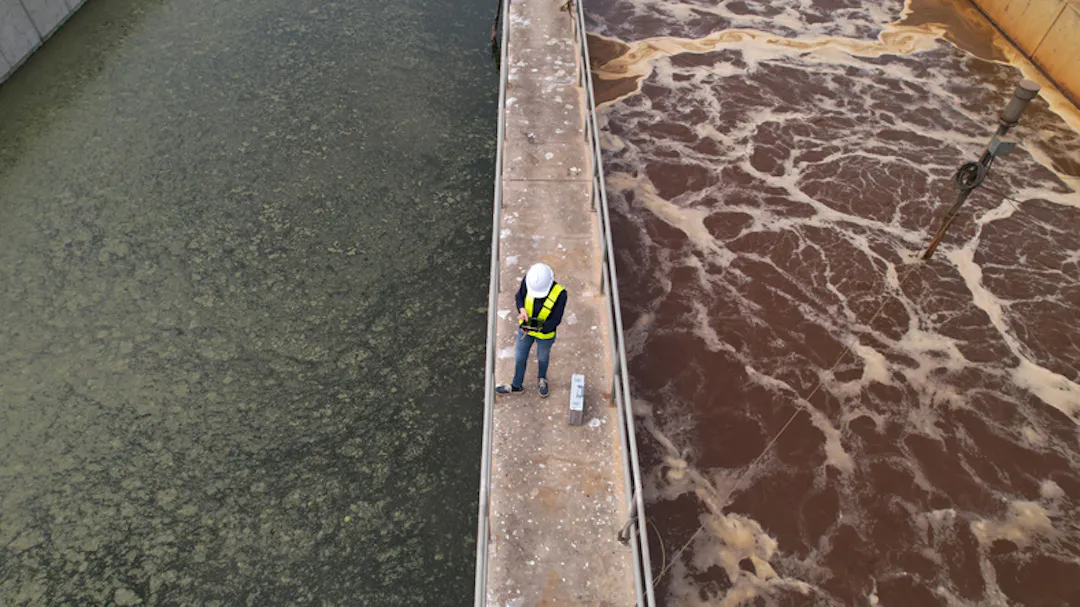 Worker standing between wastewater treatment pits