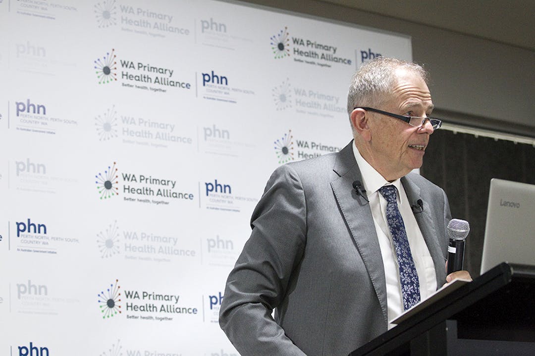 Professor Hal Swerissen speaking at the Better Health Together Forum man standing in front of lectern