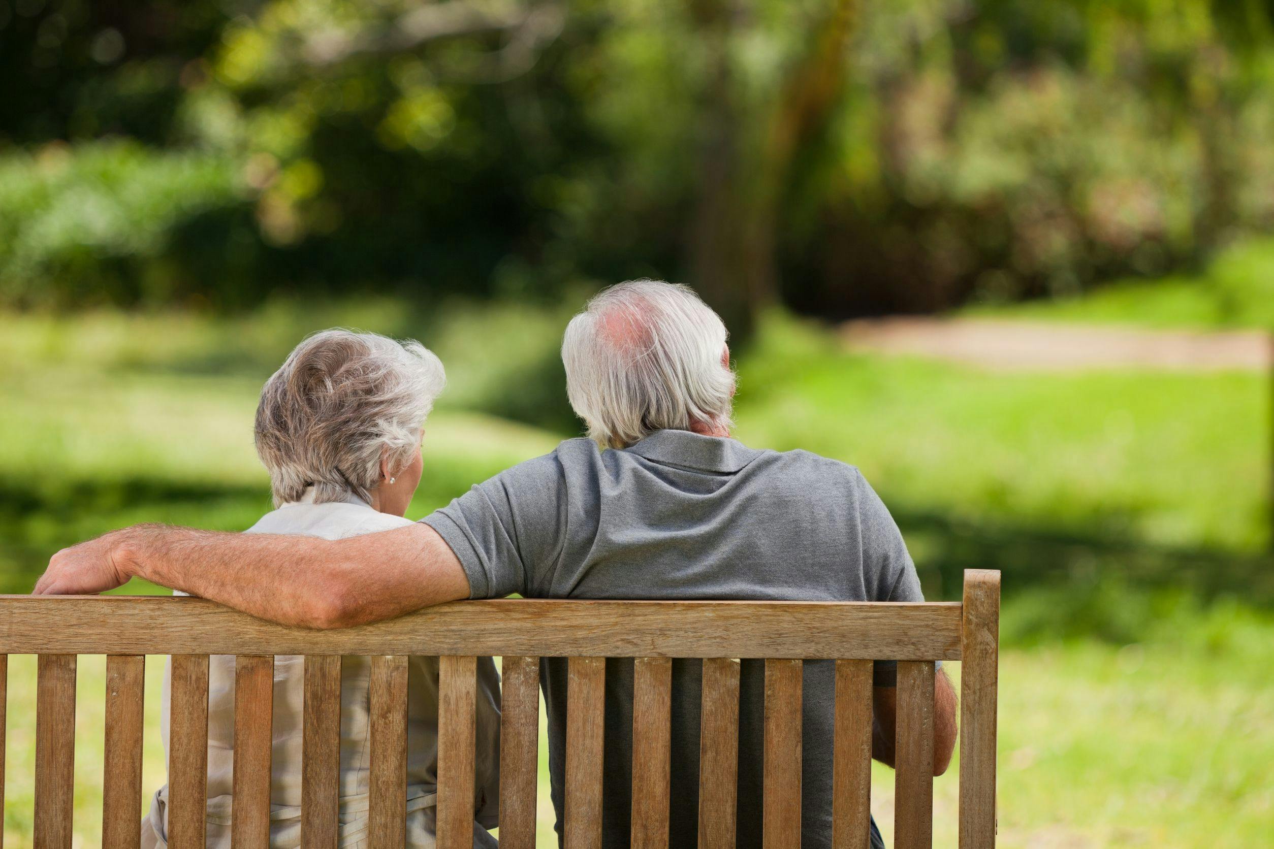 Older couple sitting on a bench in a park